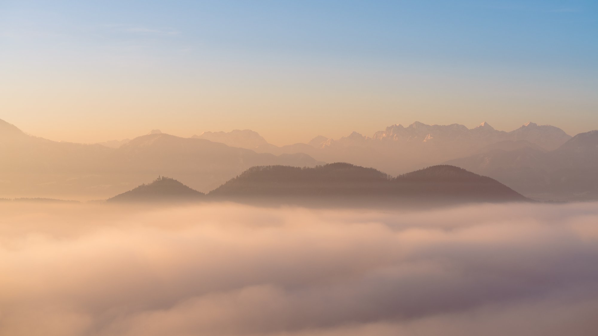 Lonely church on a peak above a sea of clouds, Carinthia, Austria