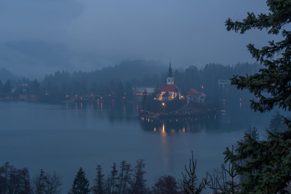 Lake bled lit up on a cold foggy winters evening, Slovenia