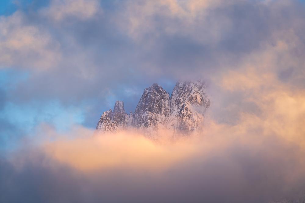 Three jagged peaks shrouded in cloud